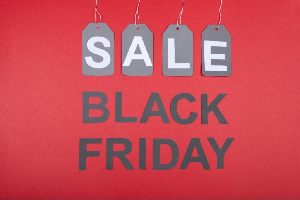 Black Friday sale sign with tags spelling “SALE,” representing promotional shipping offers and limited-time free delivery campaigns in eCommerce.