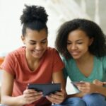 Two women shopping online with a tablet and credit card, illustrating what free shipping means for eCommerce customers and how it influences online buying behavior.